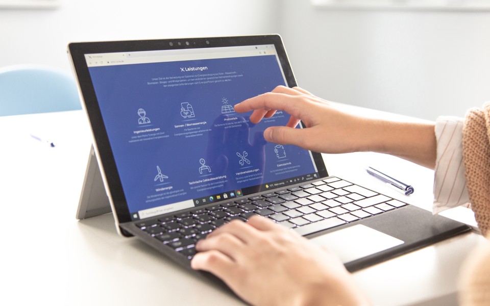 Jemand zeigt einen Website Ausschnitt am Surface