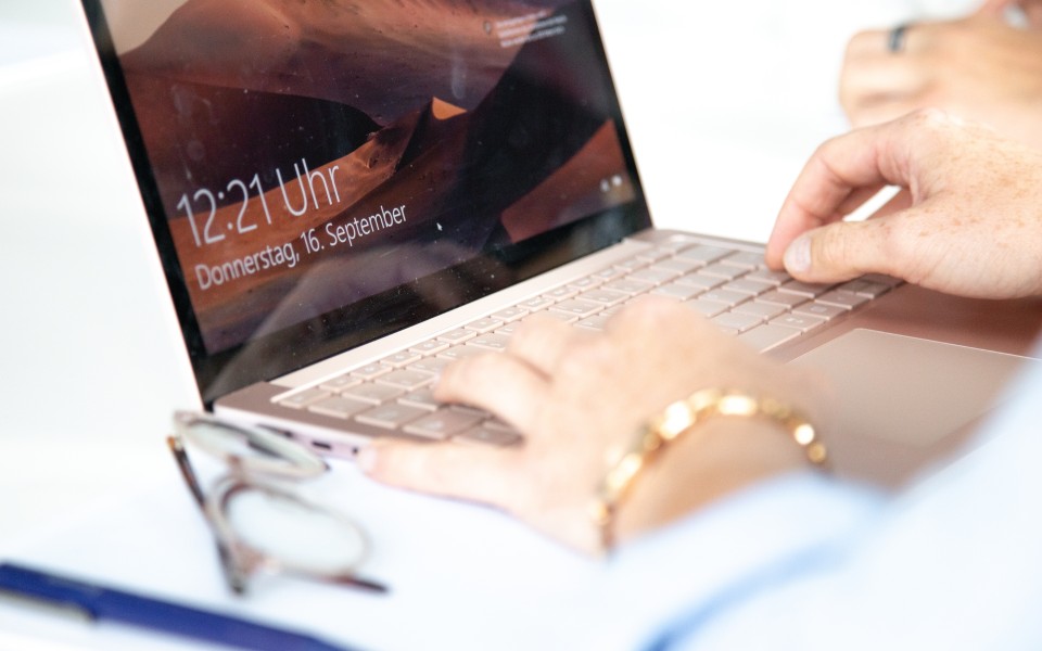 Mit den Händen auf der Laptoptastatur