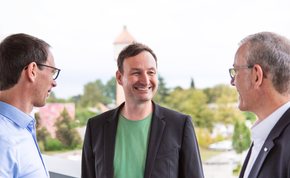 Teammitglieder unterhalten sich auf der Dachterrasse