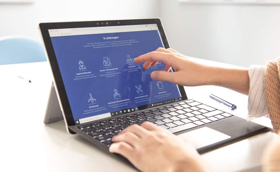 Jemand zeigt einen Website Ausschnitt am Surface